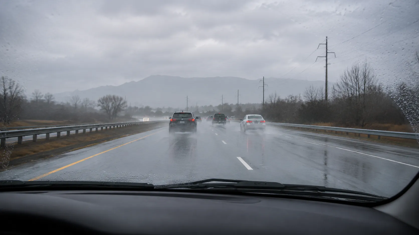Car driving safely on a wet road during steady rain