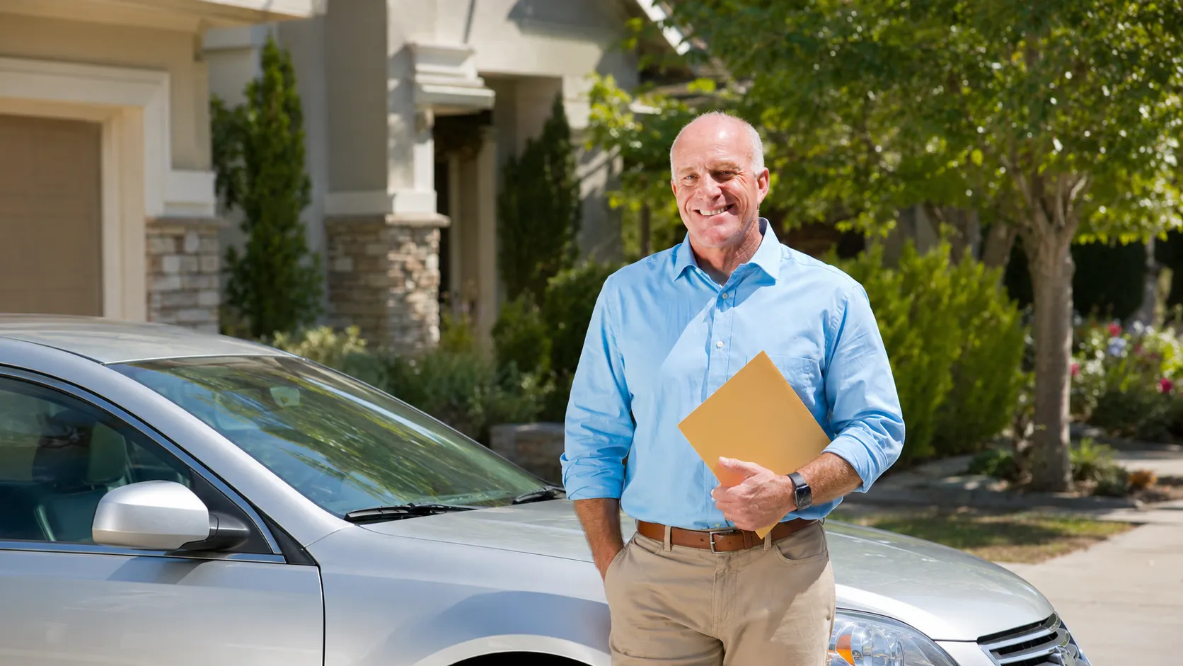 A man holding a certificate of completion after finishing a traffic school course, representing the eligibility for potential car insurance savings.