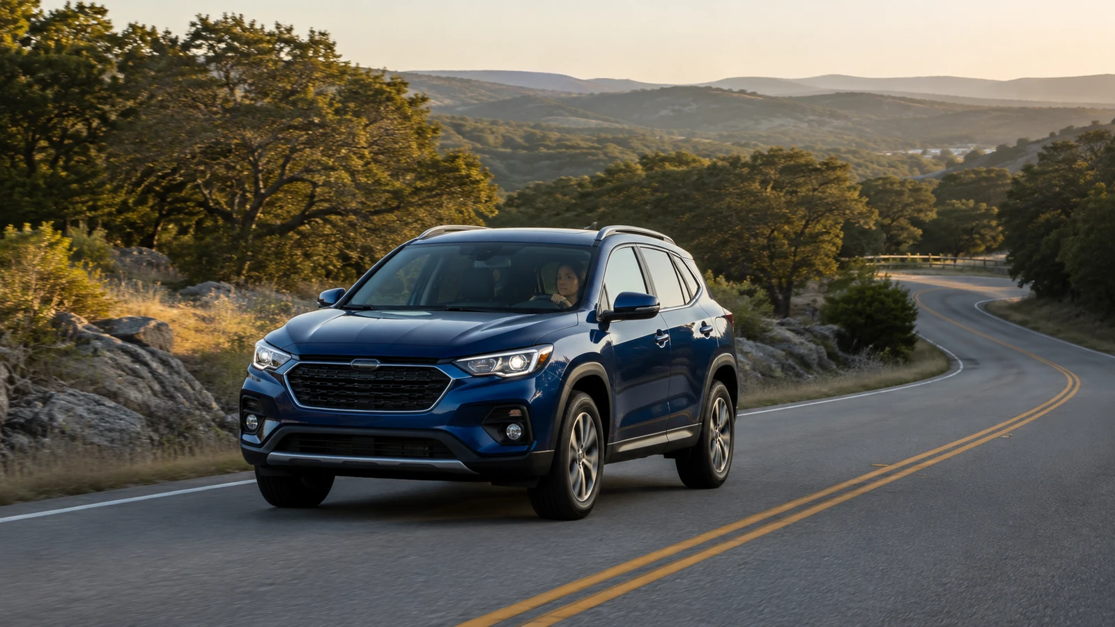 Blue SUV traveling safely on a winding Texas Hill Country road at sunrise